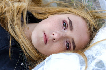 Portrait of a beautiful white blonde girl with freckles on her face