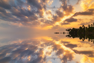 Romantic sunset on a tropical beach with palm trees