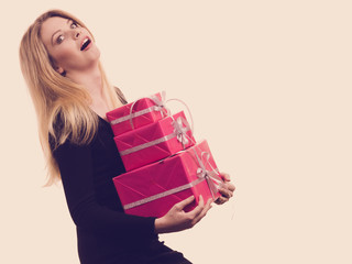 Girl carrying many pink gift boxes