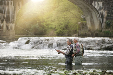 Fly fishing expert guiding novice in river