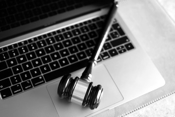 Judge gavel on laptop computer keyboard, black and white. Concept of online auction, cyber crime, law system.