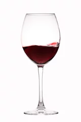 Fotobehang Red wine splashes in a glass on white background © alefat