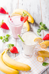 Fresh milk, strawberry, banana on wooden table, assorted protein cocktails with fresh fruits. Natural background. 