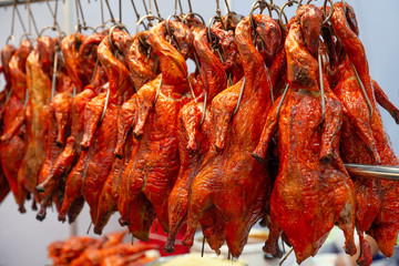row of red roasted duck hanging in chinese restaurant.