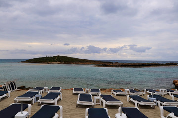 Beautiful sand beach in Ayia napa, Cyprus. Beach at dawn. Sunrise over a small hill in sea and beach. Summertime. Dawn with clouds. Vacation. Relaxing on the beach. Nissi beach