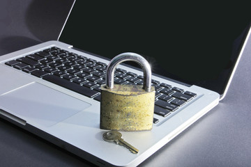 Small lock with key on computer keyboard - data security concept