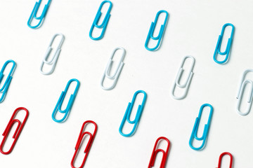Multicolored paper clips on a white background, office concept