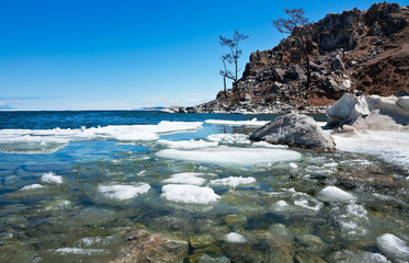 Baikal Lake in May ice drift. White ice floes at a pebble beach near Burkhan cape of Olkhon Island. Spring landscape