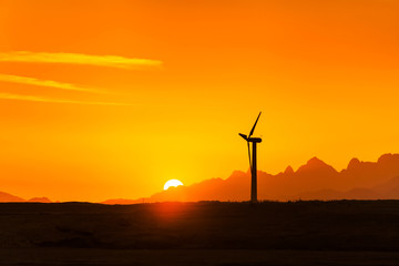 Obraz premium Big wind turbines in the desert against mountains