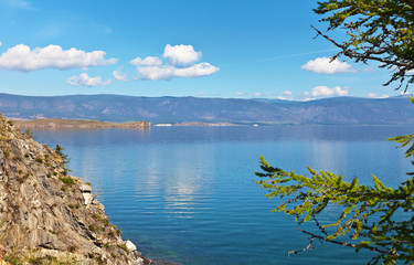 Baikal Lake on a sunny summer morning. View of the Small Sea Strait from the rocky coast of the Olkhon Island. Bright natural summer background