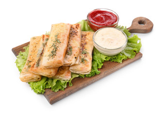 Wooden board with tasty fried spring rolls and sauces on white background