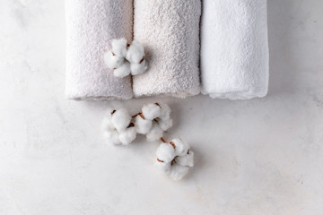 Cotton flowers with soft towels on light table