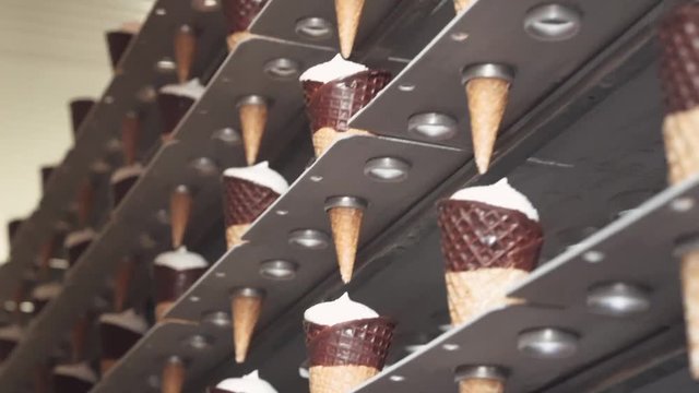 ice cream production, transportation waffle-cone with plombir ice cream on conveyor, production line, dairy products.