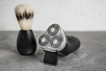 Electric trimmer with shaving brush on grey table
