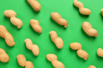 Tasty peanuts on color background