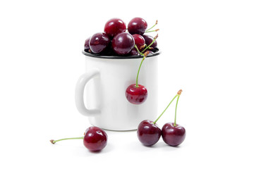 White cup with red sweet cherry isolated on a white background..