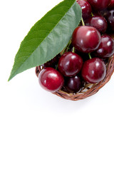 Yellow wooden basket with red sweet cherry isolated on a white background..