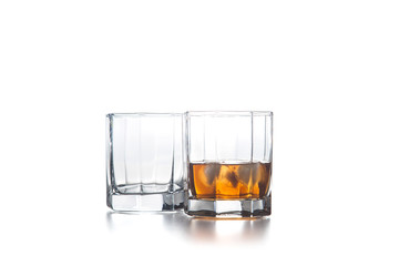 Two glasses of whiskey with ice cubes isolated on light background..