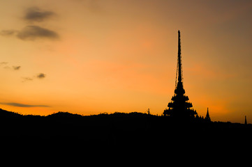 Silhouette of Thai temple on yellow sky at dawn. Buddhism belief. Traditional Thai style architecture.