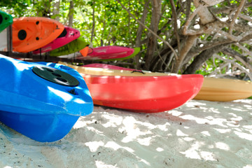 Colorful kayak canoe boat on sandy beach in tropical paradise island in sunny day in summer season. Travelling on vacation and holiday to tropical island.