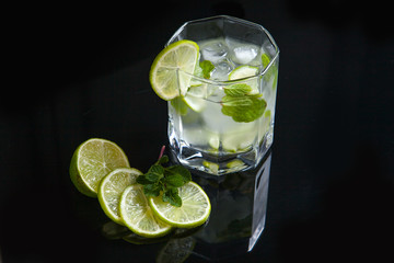 Summer cocktail mojito in glass on black background..