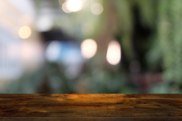 Empty dark wooden table in front of abstract blurred bokeh background of restaurant . can be used for display or montage your products.Mock up for space.