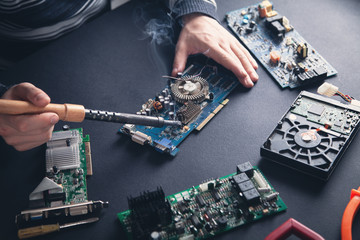 Computer hardware engineering. Engineer soldering computer motherboard