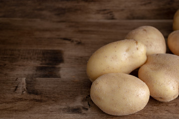 Top view of potatoes on dark wooden background with copy space