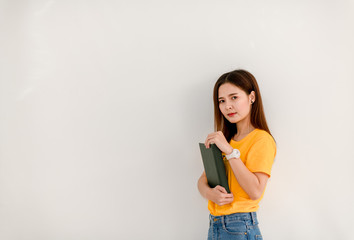 Asian girl holding a green book in front of her