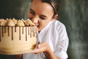 Female chef eating whole cake