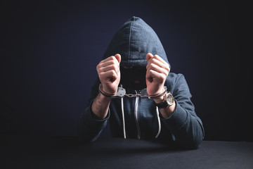 Computer hacker in handcuffs. Cyber crime
