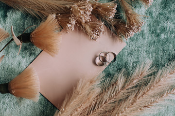 Dark flat lay wedding invitations, flowers, rings. Beautiful decor.Flat lay, top view, copy spaceFlat lay stiil life