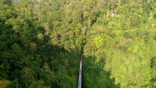 Aerial tilt shot of the waterfall of gitgit in Bali surrounded by the deep jungle.