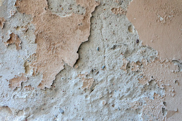 Oldgrungy weathered wall background texture. Dirty peeled plaster wall with falling off flakes of paint
