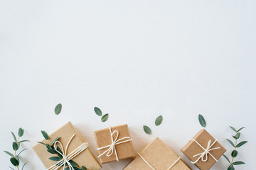 Craft gift boxes on white wooden background. Copy space for text. Eco concept