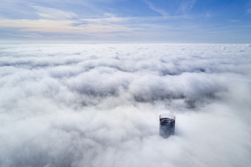 Yekaterinburg, Russia - October, 2018: Aerial shot over the clouds view of the rooftop of highest building in Yekaterinburg city - Iset Tower
