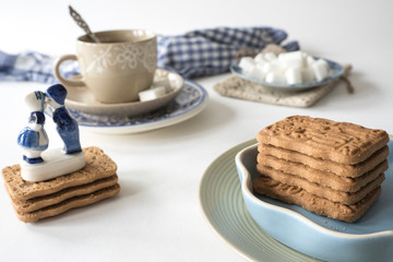 spiced cookie, Speculaas,  typical from The Netherlands. With cup of tea and Delfts Blue souvenir, on white table