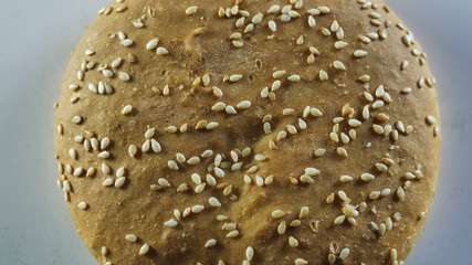 Bun sprinkled with sesame burger rotates around its axis, top view