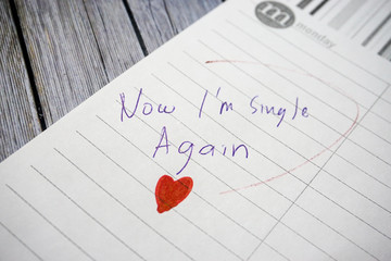 The words "wedding day" means happiness written on a white papernote to remind you an event in that day with white wooden as a background