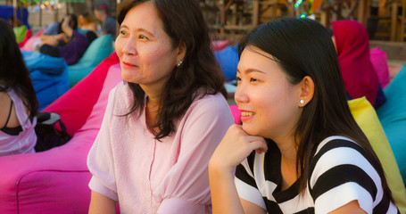 happy and beautiful Asian Chinese woman enjoying Summer holidays travel together with her senior mature mother smiling cheerful and relaxed tropical beach resort