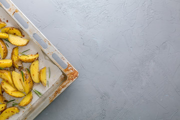 Sliced raw potatoes on a baking sheet with spices and rosemary, tio view, copy space