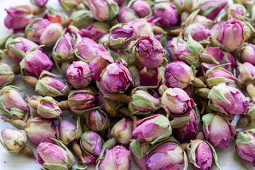 Heap of dried pink rosebuds for tea or aromatherapy. Rosebud textured flower background.