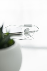 selective focus of smartphone and wired earphones isolated on white