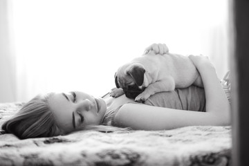 Girl and pug at home in casual in bedroom,daylight