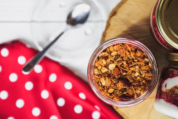 Summer fruit red berry breakfast. Healthy cherry split breakfast with cream cheese, granola, nuts and dried fruits white chocolate. In mason jar, on table. Copy space