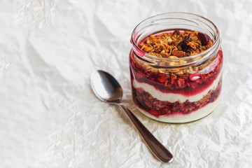 Summer fruit red berry breakfast. Healthy cherry split breakfast with cream cheese, granola, nuts and dried fruits white chocolate. In mason jar, on table. Copy space