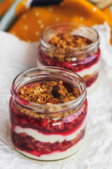 Summer fruit red berry breakfast. Healthy cherry split breakfast with cream cheese, granola, nuts and dried fruits white chocolate. In mason jar, on table. Copy space