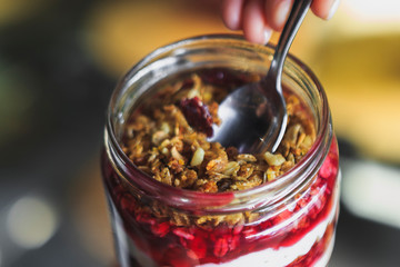Summer fruit red berry breakfast. Healthy cherry split breakfast with cream cheese, granola, nuts and dried fruits white chocolate. In mason jar, on table. Copy space