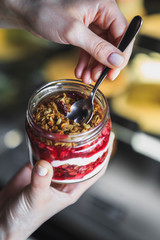 Summer fruit red berry breakfast. Healthy cherry split breakfast with cream cheese, granola, nuts and dried fruits white chocolate. In mason jar, on table. Copy space