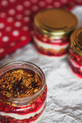 Summer fruit red berry breakfast. Healthy cherry split breakfast with cream cheese, granola, nuts and dried fruits white chocolate. In mason jar, on table. Copy space
